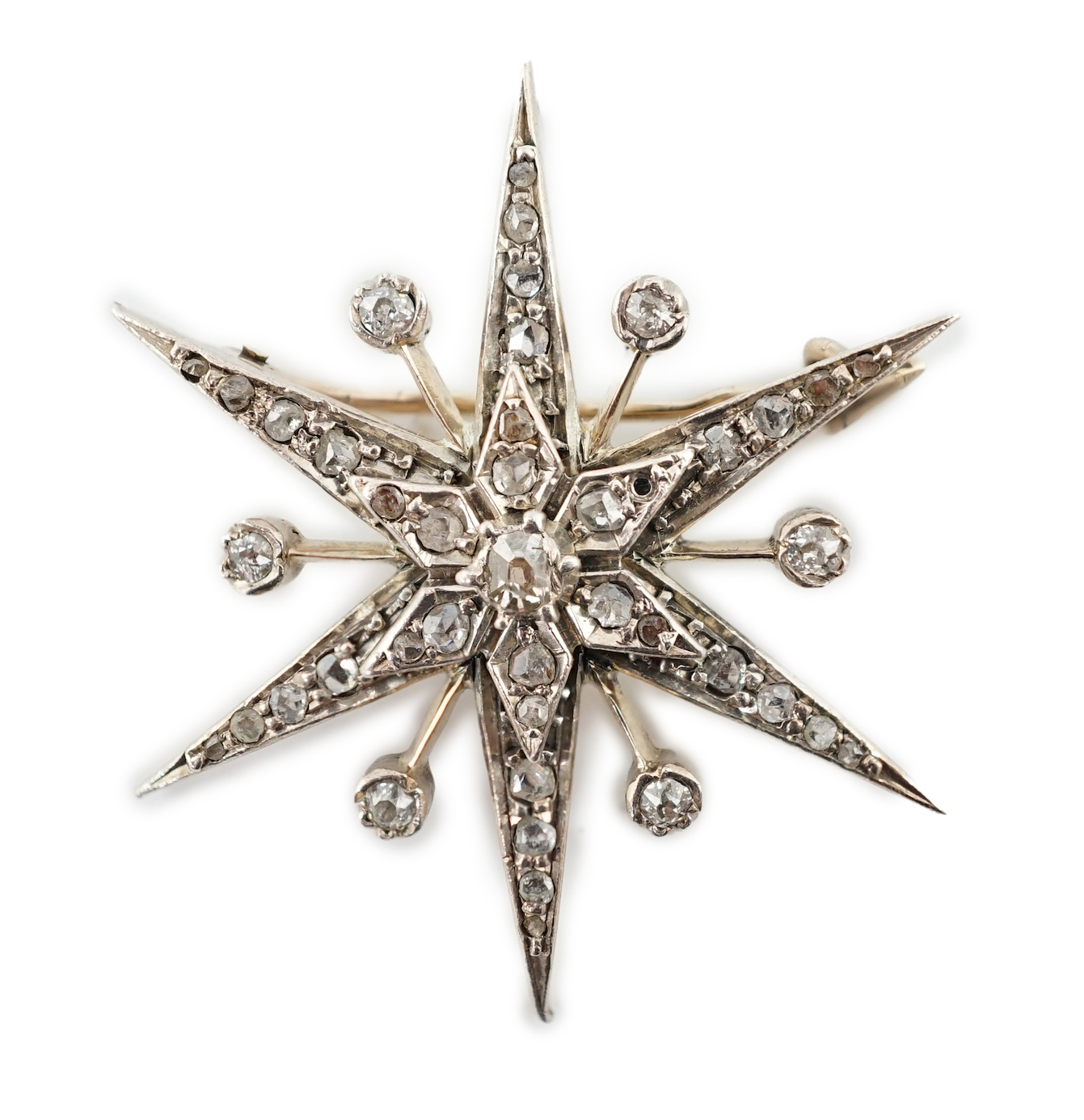 A Victorian style gold, silver and rose cut diamond cluster set starburst brooch